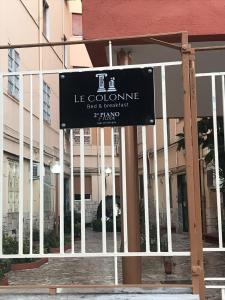 a sign on a fence in front of a building at Le Colonne B&b in Ercolano