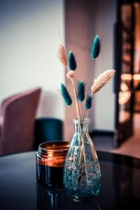 um vaso de vidro com flores sobre uma mesa em Hotel-Restaurant Osterather Hof em Meerbusch