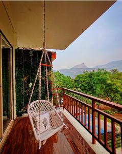 een veranda met een schommelstoel op een balkon bij ‘The Mountain Majesty’: cozy 1 bhk apartment in Karjat