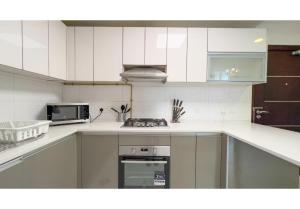 a kitchen with white cabinets and a stove top oven at HomesGetaway-Cozy Studio in Glitz 1 by Danube in Dubai