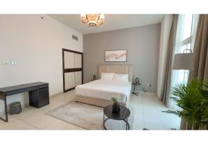 a bedroom with a bed and a table and a desk at HomesGetaway-Cozy Studio in Glitz 1 by Danube in Dubai