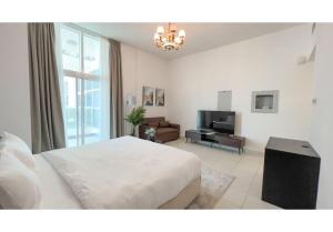 sypialnia z białym łóżkiem i salonem w obiekcie HomesGetaway-Cozy Studio in Glitz 1 by Danube w Dubaju