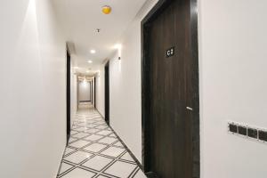 un corridoio con pareti bianche e una porta in legno scuro di FabHotel Greysky a Nuova Delhi