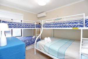- une chambre avec 2 lits superposés et un bureau dans l'établissement Summer Bay Sunsets, à Hawks Nest