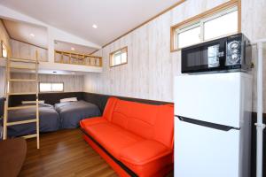 a tiny house with a couch and a bed at Hotel Japan Shiga in Yamanouchi