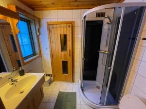 y baño con ducha, lavabo y espejo. en Cabin with a great view at Gaustablikk, en Gaustablikk