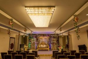 a banquet hall with a bed and a chandelier at Palm Resorts in Tinsukia