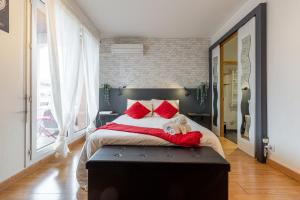 a bedroom with a large bed with red pillows at Studio ToulouseCityStay Basso Cambo in Toulouse