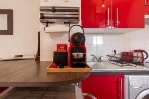 トゥールーズにあるStudio ToulouseCityStay Basso Camboのキッチン(赤いキャビネット、木製カウンタートップ付)