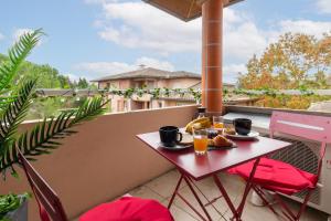 a table on a balcony with food and drinks at Studio ToulouseCityStay Basso Cambo in Toulouse