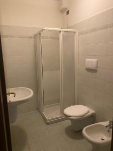 een badkamer met een douche, een toilet en een wastafel bij La Lanterna - Appartamento con Giardino in Residence con Piscina in Desenzano del Garda