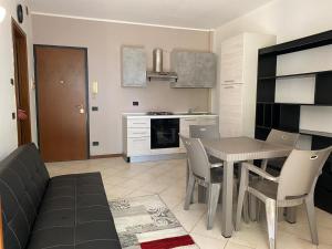 een keuken en eetkamer met een tafel en stoelen bij La Lanterna - Appartamento con Giardino in Residence con Piscina in Desenzano del Garda