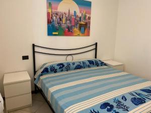een slaapkamer met een bed met een schilderij aan de muur bij La Lanterna - Appartamento con Giardino in Residence con Piscina in Desenzano del Garda