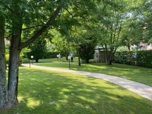 een loopbrug in een park met bomen en gras bij La Lanterna - Appartamento con Giardino in Residence con Piscina in Desenzano del Garda