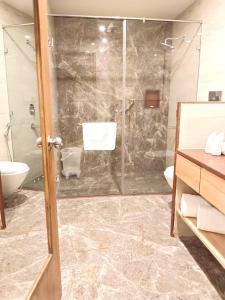 a bathroom with a shower and a toilet and a sink at Best Western Resort Country Club in Gurgaon
