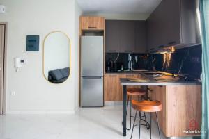 una cucina con frigorifero e 2 sgabelli da bar di MOS luxury project by Homebrain a Alexandroupoli