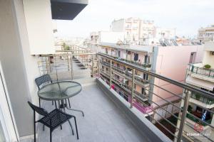 un balcone con tavolo e sedie su un edificio di MOS luxury project by Homebrain a Alexandroupoli