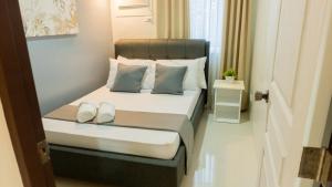 a bedroom with a bed with two shoes on it at Affordable and Elegant 2BR Apartment with a Balcony plus FREE Swimming Pool and Gym-5Kunzite in Puerto Princesa City