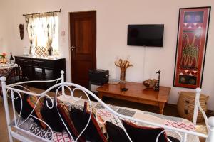 a living room with a bed and a tv at Sebakwe in Dullstroom