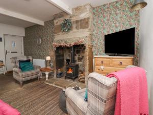a living room with a fireplace and a tv at Penistone View in Keighley