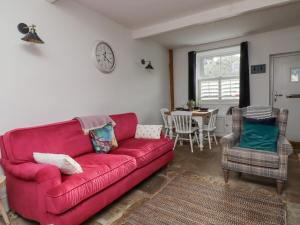 a living room with a red couch and a table at Penistone View in Keighley