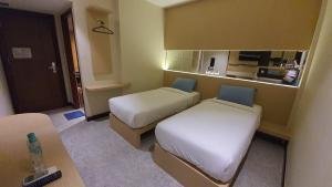 Habitación pequeña con 2 camas y cocina en MP Hotel Kelapa Gading en Yakarta