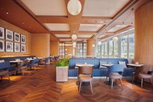 a dining room with tables and chairs and windows at Intercity Hotel Futian Zhongzhou Bay in Shenzhen