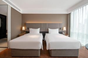 Voodi või voodid majutusasutuse Intercity Hotel Futian Bin He Zhongzhou Bay toas