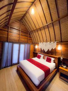 sypialnia z dużym łóżkiem w drewnianym pokoju w obiekcie Pinggan caldera w mieście Baturaja