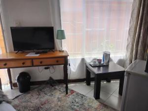 sala de estar con escritorio y TV. en 54 Brecher en Pretoria