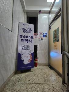 a corridor of a hallway with a sign in a building at Gangnam Best Dormitory in Seoul
