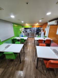 a restaurant with white tables and green chairs at Gangnam Best Dormitory in Seoul