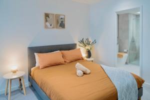- une chambre avec un grand lit et des oreillers orange dans l'établissement Minutes from Melbourne CBD - FREE Parking, à Footscray