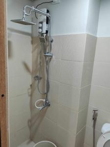 uma casa de banho com um chuveiro e um WC. em Metropolis Staycation at Grass Residences em Manila