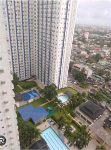 uma vista aérea de um edifício alto com uma piscina em Metropolis Staycation at Grass Residences em Manila