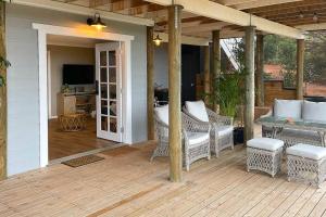 un patio con sillas de mimbre y una mesa en una terraza. en Gorgeous apartment - pet friendly, stunning views, en Bridgetown