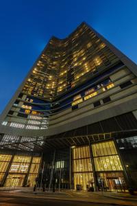 un grand bâtiment avec de nombreuses fenêtres la nuit dans l'établissement DAMAC Maison Aykon City Dubai, à Dubaï
