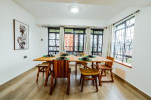 a dining room with a wooden table and chairs at Sky Oasis Home in Nairobi