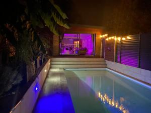 - une piscine avec des lumières bleues dans une maison dans l'établissement L'Eden, à Saint-Rémy-lès-Chevreuse
