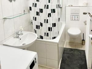 La salle de bains blanche est pourvue d'un lavabo et de toilettes. dans l'établissement Beautiful Apartment in Düren, à Düren