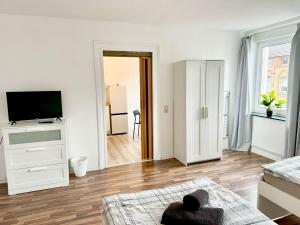 - un salon blanc avec une télévision et un canapé dans l'établissement Beautiful Apartment in Düren, à Düren
