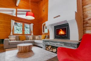 uma sala de estar com lareira e uma cadeira vermelha em Chalet Soleada - Happy Rentals 
