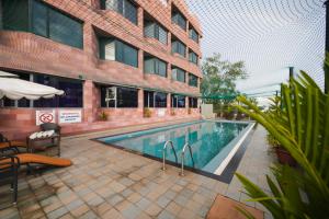a swimming pool in front of a building at The South Park Hotel in Trivandrum