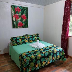 1 dormitorio con 1 cama con edredón verde en Maruhana lodge, en Teahupoo