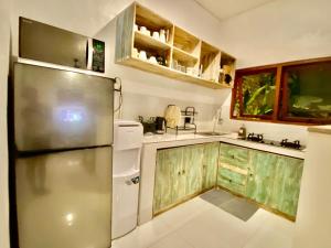 una cocina con nevera de acero inoxidable y armarios de madera en Timaya Villa, en Legian