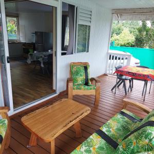 un porche cubierto con mesa y silla en Maruhana lodge, en Teahupoo