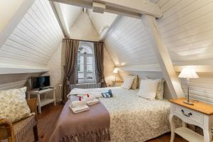 ブルージュにあるHet Geerwijn - gastensuite in hartje Bruggeの屋根裏のベッドルーム(ベッド1台、テレビ付)