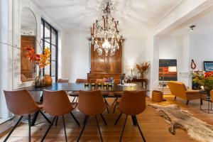comedor con mesa, sillas y lámpara de araña en Het Geerwijn - gastensuite in hartje Brugge en Bruges