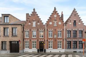 un antiguo edificio de ladrillo con dos torretas en Het Geerwijn - gastensuite in hartje Brugge en Brujas