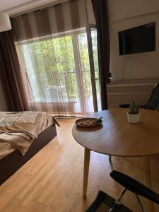 a living room with a table and a large window at Vanagupės 24 in Palanga